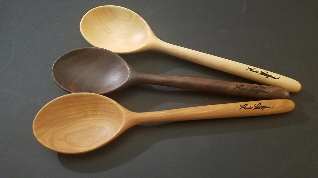 Three handmade wood spoons on a table top