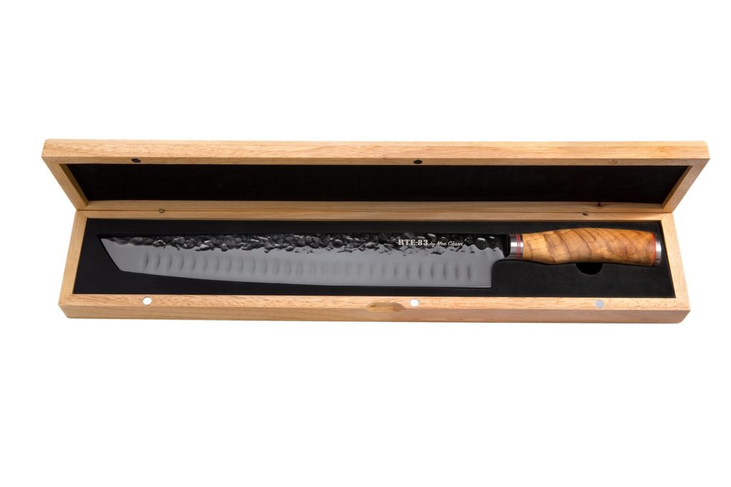 Moe Cason cutlery brisket XXL fourteen inch carving knife with natural wooden handle displayed n the included wooden case.